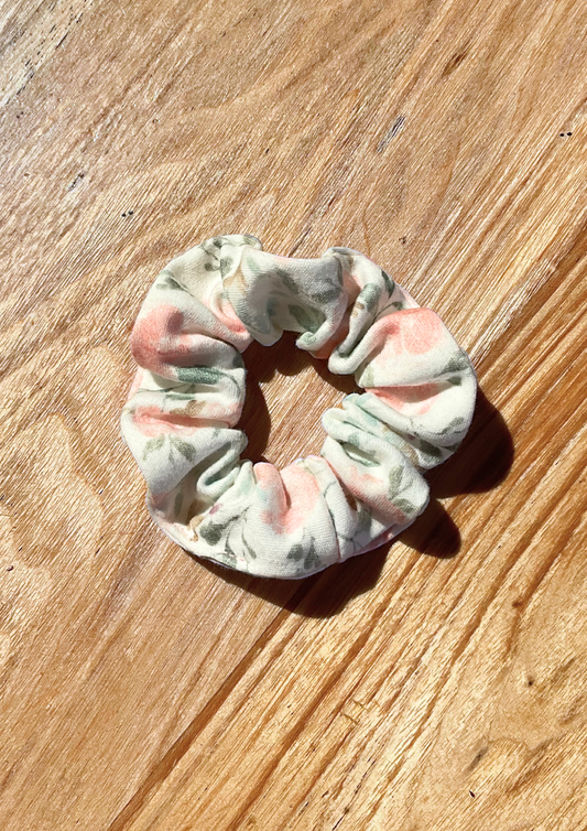 Garden Floral Scrunchie. Pastel peach pink floral pattern with soft green leaves on off white background. Eravela handmade organic cotton scrunchie with soft organic cotton elastic.

