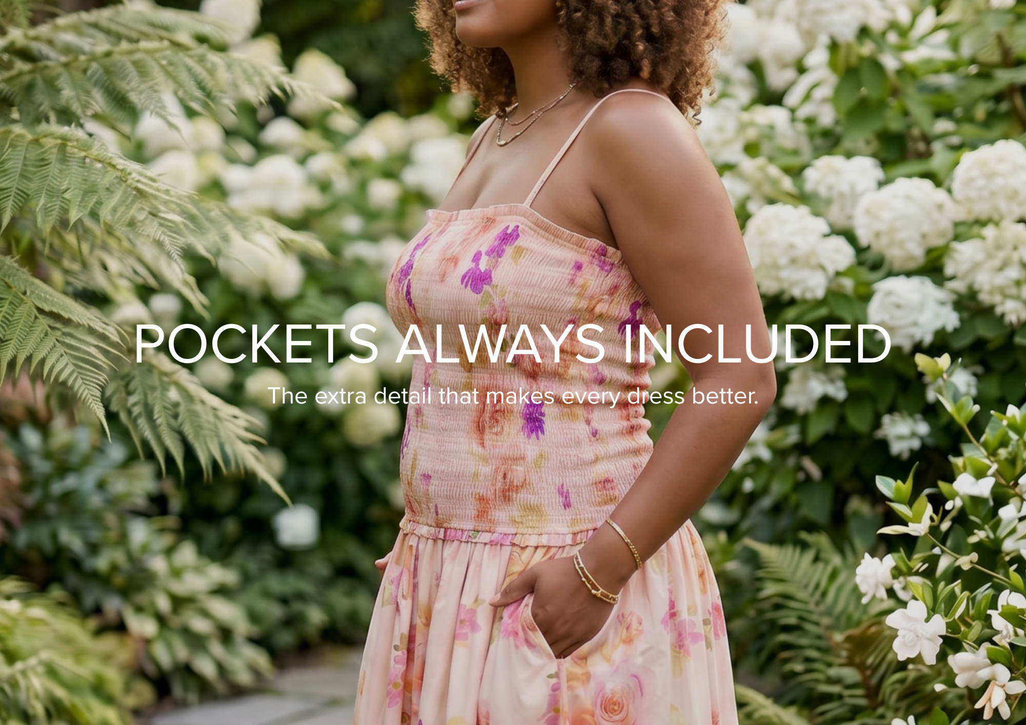 A woman wearing a black off-the-shoulder maxi dress with tiered ruffles stands outdoors on a stone path surrounded by pink flowering bushes. The text 'SUBTLE ENCHANTMENT' appears at the bottom with the tagline 'Destined To Enhance Your Natural Radiance'.