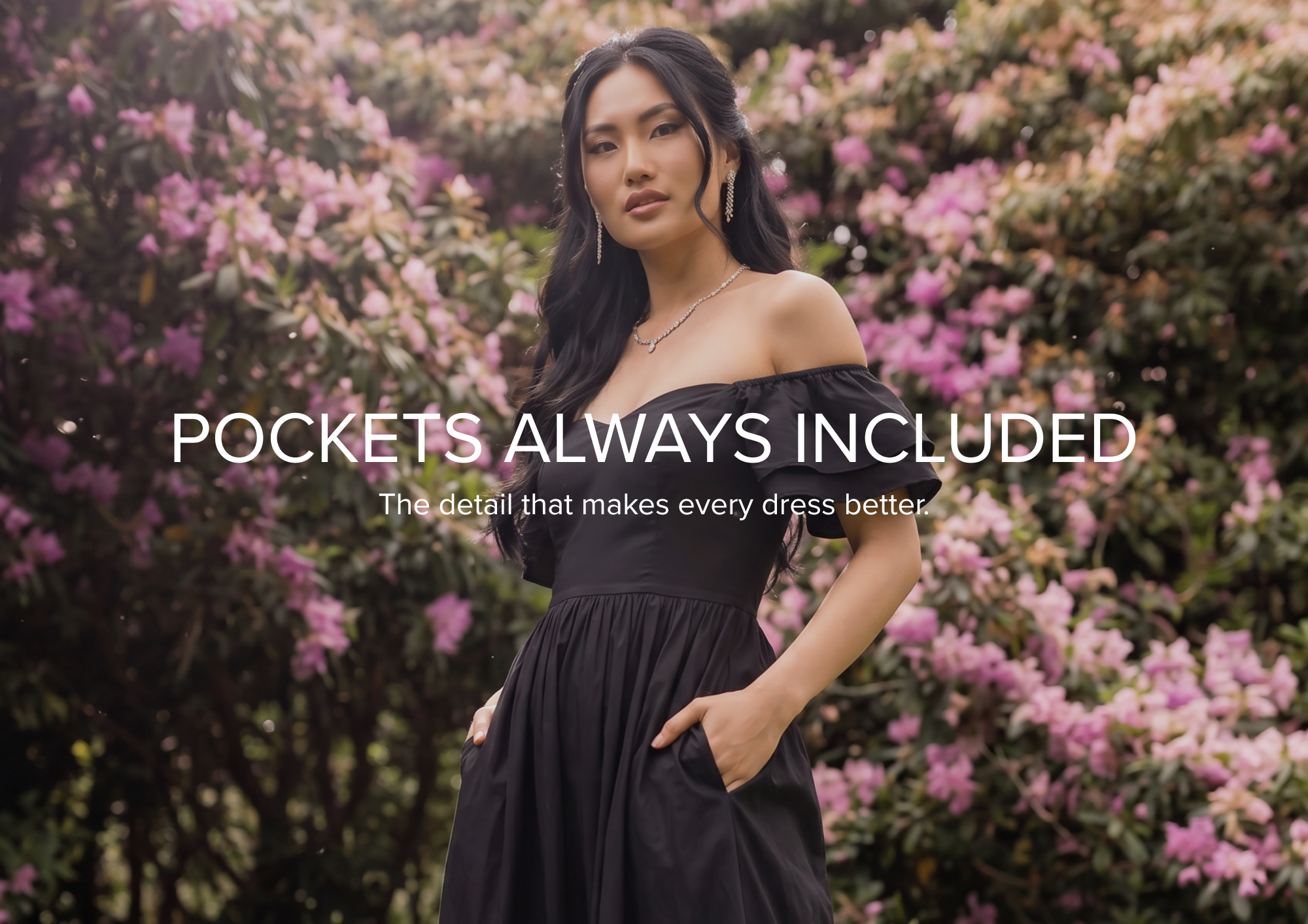 A woman wearing a black dress with ruffled sleeves and pockets stands outdoors in front of pink flowering bushes, with the text 'POCKETS ALWAYS INCLUDED' overlaid across the center.